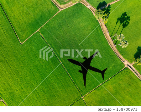 Shadow airplane flying above green field. Sustainable aviation fuel. Sustainable transportation and eco-friendly flight with biofuel use. Aviation sustainability. Air travel. Reduce carbon footprint. Shadow airplane flying above green field. Sustainable aviation fuel. Sustainable transportation and eco-friendly flight with biofuel use. Aviation sustainability. Air travel. Reduce carbon footprint. 138700973
