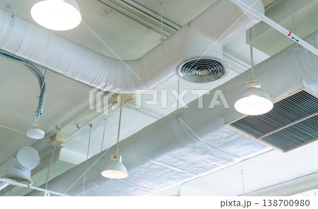 Air duct, air conditioner pipe and fire sprinkler system on white ceiling wall. Air flow and ventilation system. Building interior. Ceiling lamp light with opened light. Interior architecture concept. 138700980