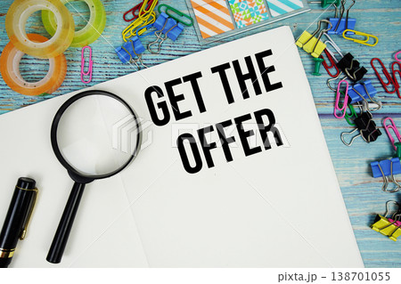 Get The Offer text written on notepad with magnifying glass flat lay on wooden background 138701055