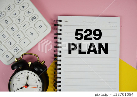 529 Plan text written on notepad with calculator and alarm clock on pink background 138701084