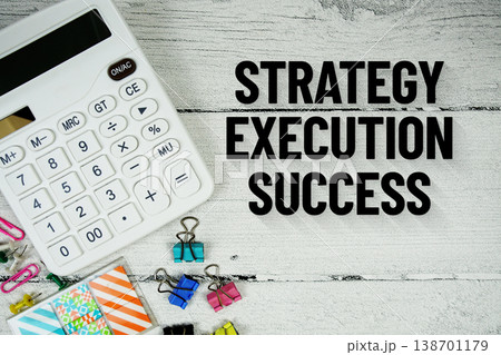 Strategy Execution Success text message with calculator and stationery on wooden background Strategy Execution Success text message with calculator and stationery on wooden background 138701179