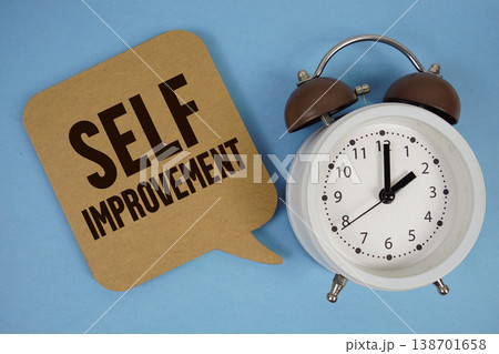 Self Improvement text with alarm clock on blue background 138701658