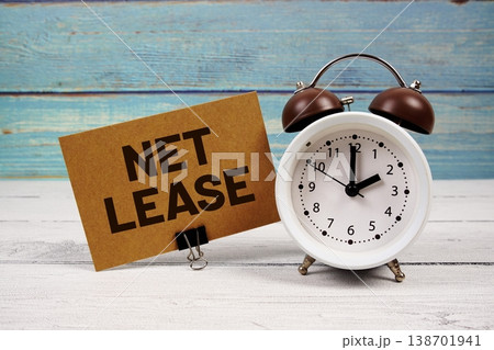 Net Lease text written on paper card with alarm clock on wooden background Net Lease text written on paper card with alarm clock on wooden background 138701941