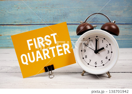 First Quarter text written on paper card with alarm clock on wooden background First Quarter text written on paper card with alarm clock on wooden background 138701942