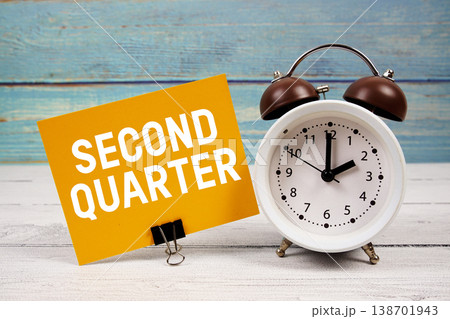 Second Quarter text written on paper card with alarm clock on wooden background Second Quarter text written on paper card with alarm clock on wooden background 138701943