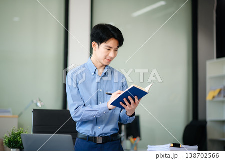Confident Asian businessman typing laptop computer and digital tablet at office Confident Asian businessman typing laptop computer and digital tablet at office 138702566