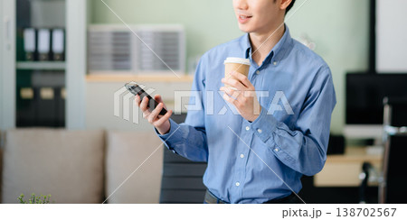 Confident Asian businessman typing laptop computer and digital tablet at office Confident Asian businessman typing laptop computer and digital tablet at office 138702567
