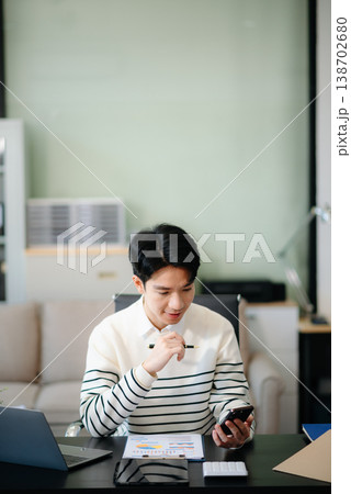 Young business man working at office with laptop, tablet and taking notes on the paper. Young business man working at office with laptop, tablet and taking notes on the paper. 138702680