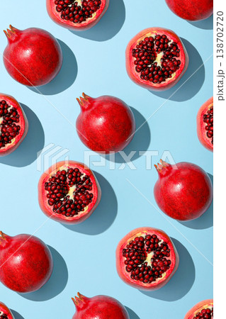 Red pomegranates spread out on a light blue surface 138702720