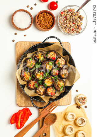 Mushrooms filled with vegetables and cheese on a wooden tray Mushrooms filled with vegetables and cheese on a wooden tray 138702742