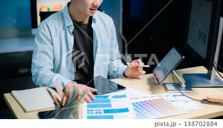 Asian male programmer working with tablet, laptop, and desktop in tech office. Coding, software development Asian male programmer working with tablet, laptop, and desktop in tech office. Coding, software development 138702884