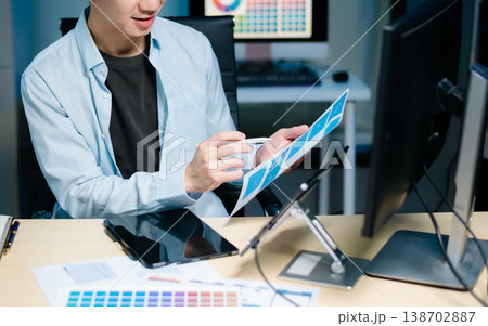 Asian UX,UI designer reviewing app wireframes and color samples in modern office. Creative process, web design Asian UX,UI designer reviewing app wireframes and color samples in modern office. Creative process, web design 138702887