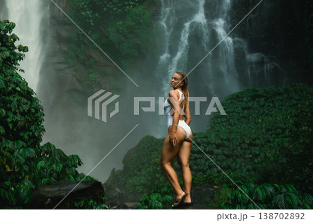 A model poses by a waterfall surrounded by lush greenery A model poses by a waterfall surrounded by lush greenery 138702892