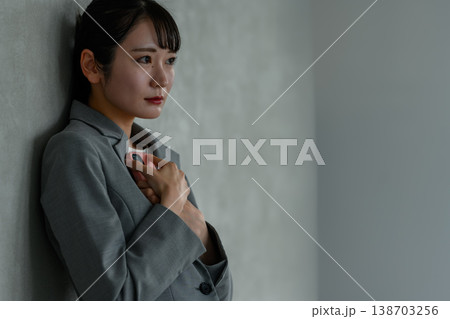 スマホを抱えて悩むビジネスウーマン 138703256