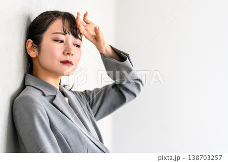 壁際で考え込むビジネスウーマン 138703257