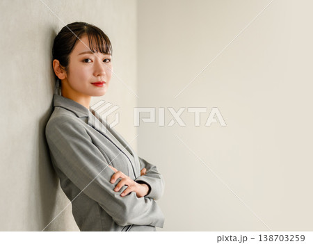 壁に寄りかかる自信に満ちたビジネスウーマン 138703259