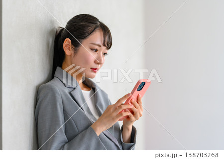 スマホを操作するビジネスウーマンの横顔 138703268