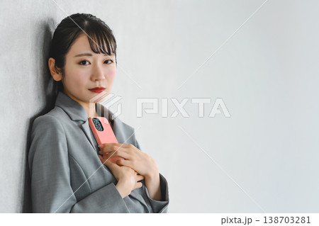 カメラ目線でスマホを持つビジネスウーマン 138703281