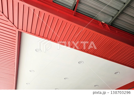 Modern ceiling design incorporating white PVC panels bordered by red. 138703296