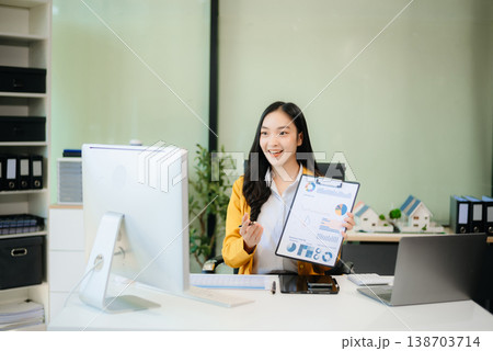 Asian businesswoman working with working notepad, tablet and laptop documents talking on the smartphone, tablet Asian businesswoman working with working notepad, tablet and laptop documents talking on the smartphone, tablet 138703714