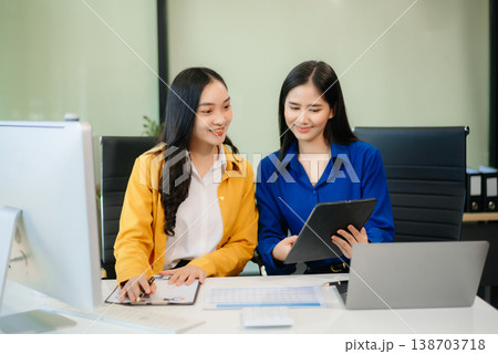 Business professionals collaborating in a modern office, planning and discussing ideas with laptops. Business professionals collaborating in a modern office, planning and discussing ideas with laptops. 138703718
