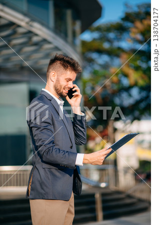 Successful Businessman in suit using tablet outdoors. Perfect for corporate, technology, and professional themes 138704177
