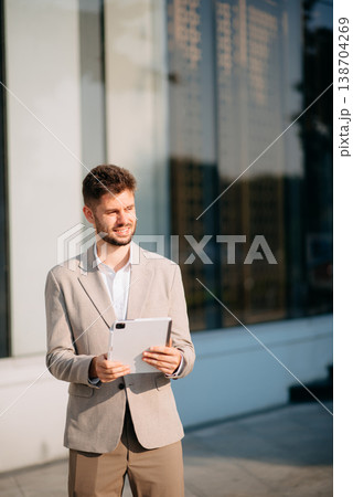 Businessman standing outdoors and using digital tablet. Perfect for corporate, technology, and professional themes 138704269