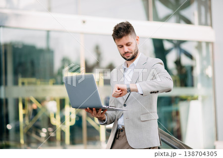 Businessman standing outdoors and using digital tablet. Perfect for corporate, technology, and professional themes Businessman standing outdoors and using digital tablet. Perfect for corporate, technology, and professional themes 138704305