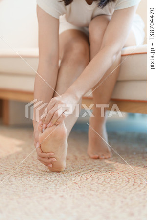 woman having barefoot pain at home. Foot ache due to Plantar fasciitis and waking longtime. Health and medical concept woman having barefoot pain at home. Foot ache due to Plantar fasciitis and waking longtime. Health and medical concept 138704470