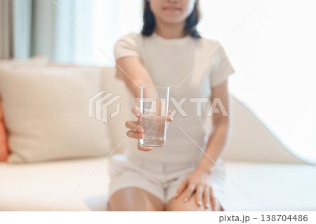 Healthy woman hold glass of clean mineral water glass on sofa at home, female drink pure water for hydration and wellness, fresh skin care, daily routine water intake, Refreshment and lifestyle Healthy woman hold glass of clean mineral water glass on sofa at home, female drink pure water for hydration and wellness, fresh skin care, daily routine water intake, Refreshment and lifestyle 138704486