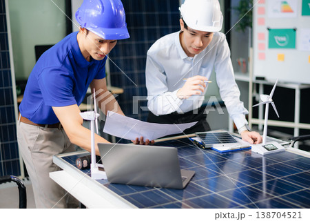 Two Asian engineers collaborate on solar and wind energy, driving clean innovation and sustainability. Two Asian engineers collaborate on solar and wind energy, driving clean innovation and sustainability. 138704521