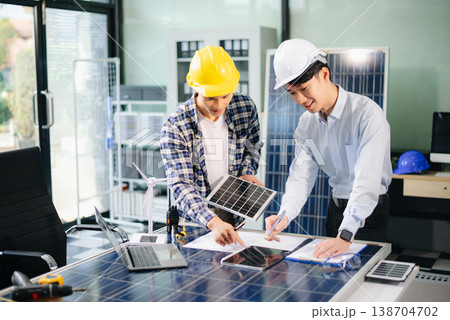 Two Asian engineers collaborate on a solar and wind energy project, discussing innovation Two Asian engineers collaborate on a solar and wind energy project, discussing innovation 138704702