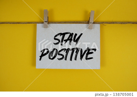 Stay Positive text written on paper card with rope and wooden clip hanging Stay Positive text written on paper card with rope and wooden clip hanging 138705001