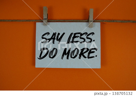 Say Less Do More text written on paper card with rope and wooden clip hanging Say Less Do More text written on paper card with rope and wooden clip hanging 138705132