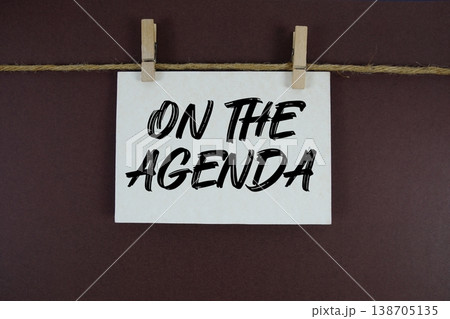 On the Agenda text written on paper card with rope and wooden clip hanging On the Agenda text written on paper card with rope and wooden clip hanging 138705135