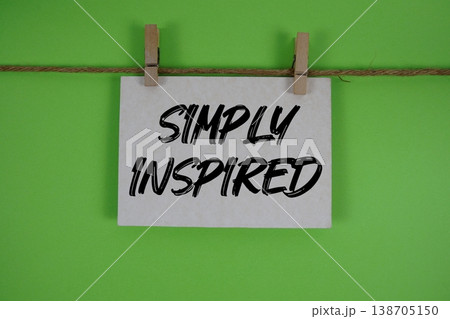 Simply Inspired text written on paper card with rope and wooden clip hanging Simply Inspired text written on paper card with rope and wooden clip hanging 138705150