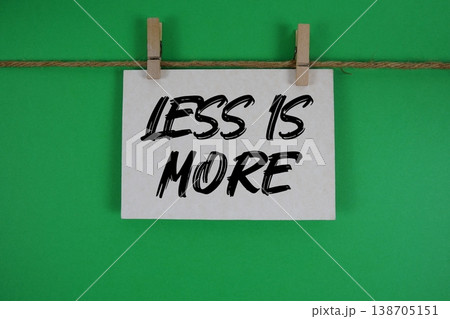 Less is More text written on paper card with rope and wooden clip hanging Less is More text written on paper card with rope and wooden clip hanging 138705151