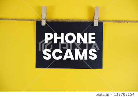 Phone Scams text written on paper card with rope and wooden clip hanging Phone Scams text written on paper card with rope and wooden clip hanging 138705154