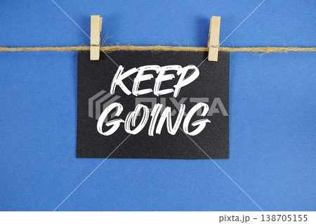 Keep Going text written on paper card with rope and wooden clip hanging 138705155