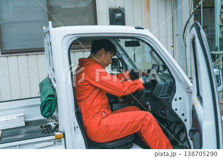 軽トラに乗るつなぎ姿の男性 138705290