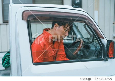 軽トラに乗るつなぎ姿の男性 軽トラに乗るつなぎ姿の男性 138705299