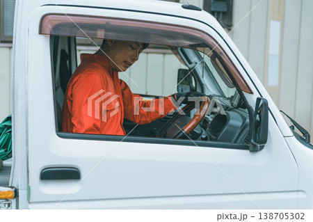 軽トラに乗るつなぎ姿の男性 138705302