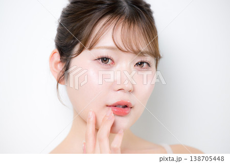 透明感のあるツヤ肌と潤いのある美しい肌の若い女性のリップケアや唇に触れる 138705448