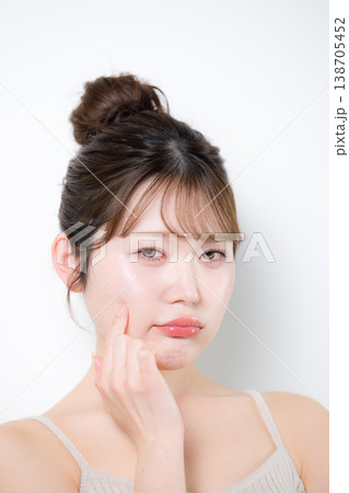 透明感のあるツヤ肌でもニキビや吹き出物に困って悩む表情の美容やスキンケアイメージのクローズアップ 138705452