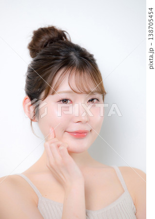 透明感のあるツヤ肌と潤いともちもちとぷるぷるの美しい赤ちゃん肌若い女性頬を触れる 138705454