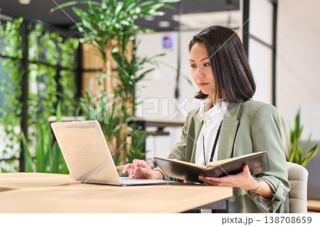 外資系IT企業のオフィスでスマホを見ながらメモを取る女性SE 外資系IT企業のオフィスでスマホを見ながらメモを取る女性SE 138708659