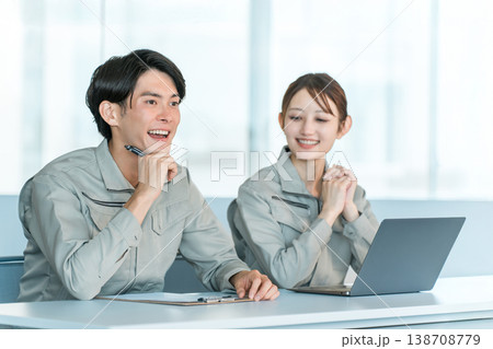 面接,面談,ディスカッションするデスクに並ぶ作業着姿の男女スタッフ 138708779