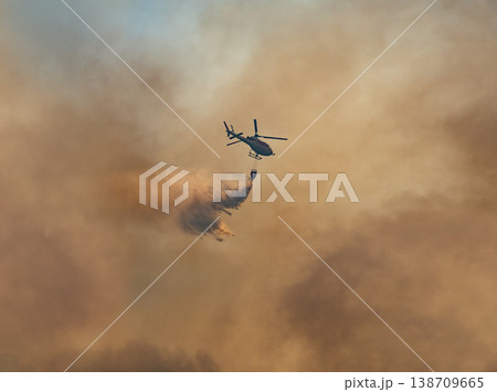 Fire fighting helicopter carry watethar bucket to extinguish the forest fire. 138709665