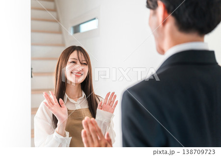 朝出勤する夫・旦那を笑顔で見送りする若いアジア人女性・妻 138709723