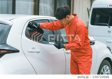 乗用車とツナギ姿の男性 乗用車とツナギ姿の男性 138710086